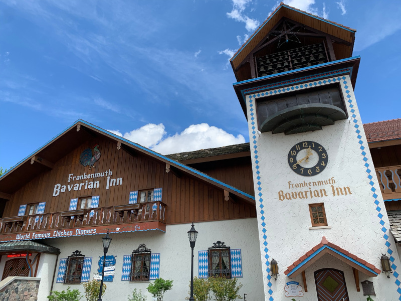 Un restaurant construit comme une auberge bavaroise : murs blancs, horloge gothique et volets en bois.