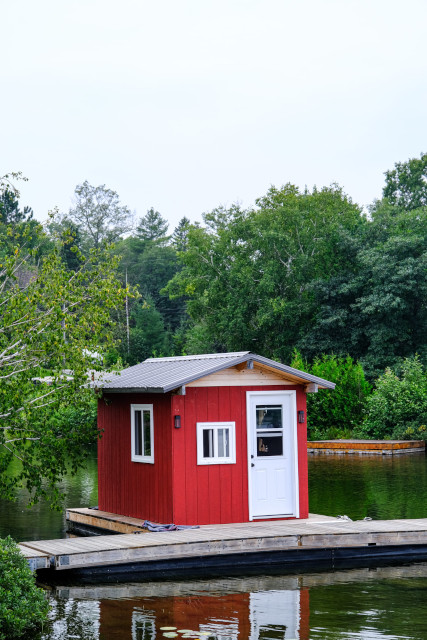 Une petite cabine rouge amarrée à un ponton sur un lac
